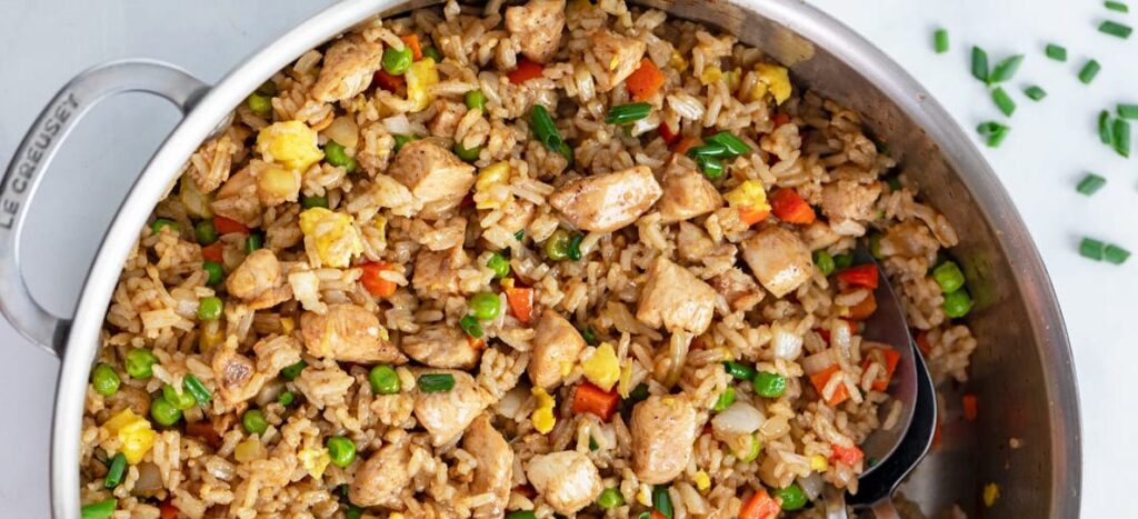 Classic chicken fried rice with scrambled egg, spring onions, and a hint of soy sauce, served in a bowl.