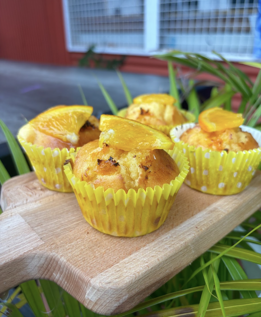 Zesty lemon muffins with a light glaze and a sprinkle of lemon zest, served on a rustic plate.